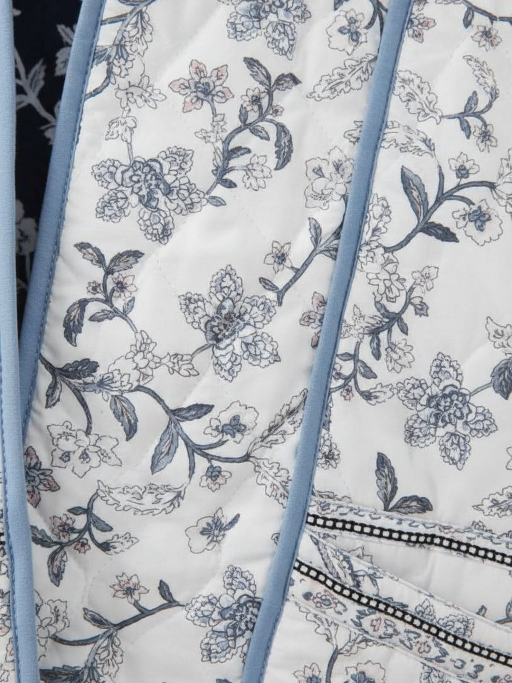 Gros plan sur les surpiqûres et le motif floral de la face blanche