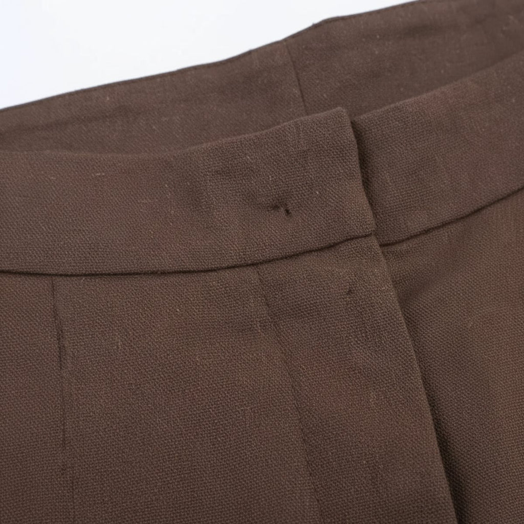 Détail de la taille haute et des plis du pantalon marron
